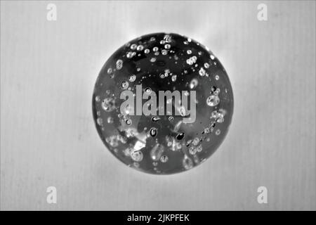 A closeup shot of a glass ball with bubbles on a white background Stock Photo