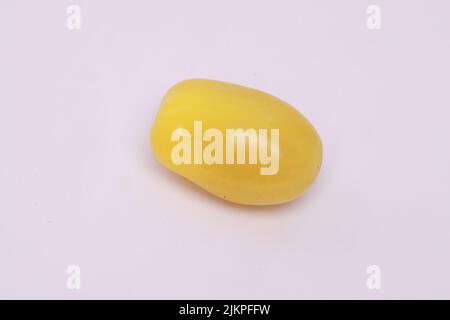 A closeup of a yellow cherry tomato isolated on a white background Stock Photo