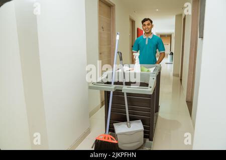 housekeepers in uniform walking pushing carts filled with cleaning supplies Stock Photo