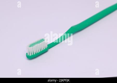 A closeup of a green toothbrush isolated on white background. Stock Photo