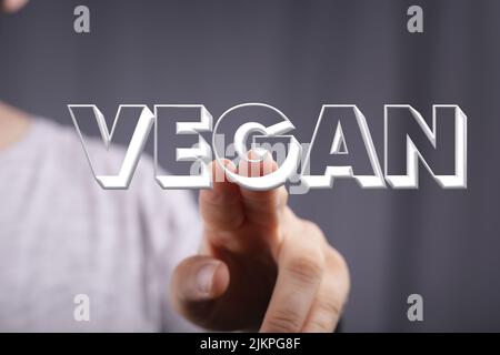 A person's hand showing illustrated Vegan in a presentation. Organic production concept Stock Photo