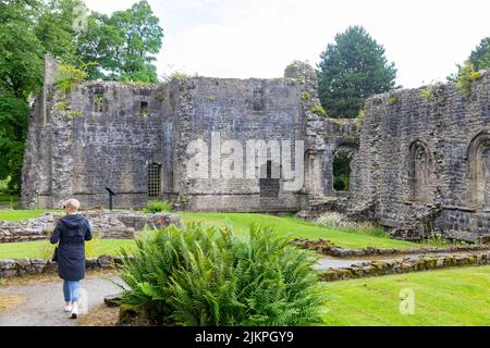 Whalley abbey ruins and grounds in Lancashire, woman visitor model released, in her early fifties, visits abbey ruins and tours the site,England,UK Stock Photo