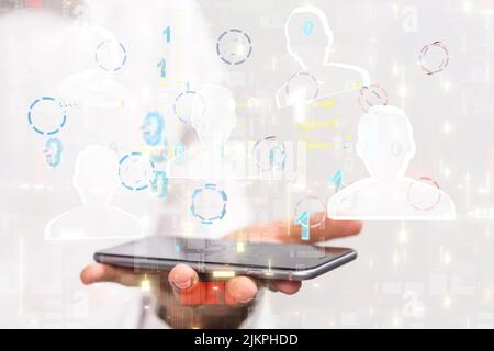 A 3D rendering of human icons and binary codes over hand holding mobile phone Stock Photo