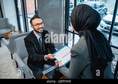 Business adviser analyzing financial of the company giving a proposal to her partner Stock Photo
