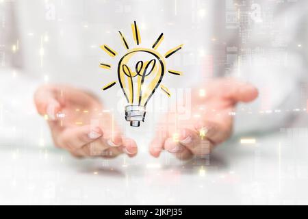 A hovering lightbulb icon floating on man's hands against a blurry white background Stock Photo