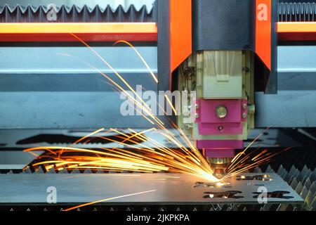 Close-up a laser cutting machine is working with a steel plate until it sparks on smart factory, industry 4.0 Stock Photo