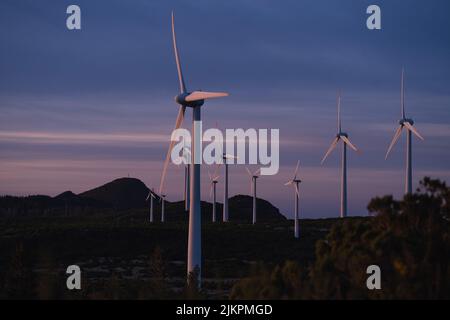 A farm of wind turbines on Madeira Island in Portugal at dusk Stock Photo