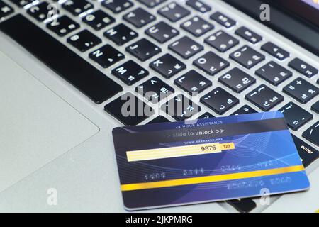 Blue credit card on locked mode put on keyboard of modern laptop, online shopping and payment via credit card concept Stock Photo