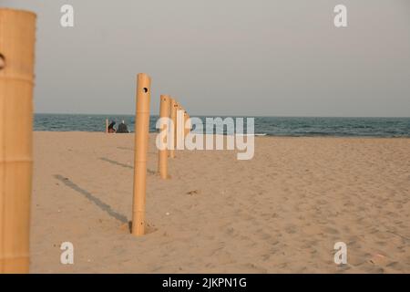 The wooden poles with holes for a rope on the beach Stock Photo