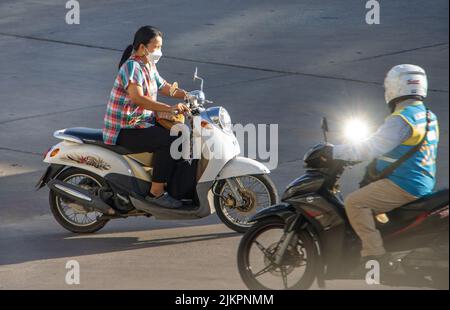 SAMUT PRAKAN, THAILAND, MAY 26 2022, A woman with face mask rides a motorcycle Stock Photo