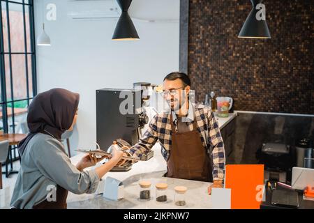 barista taking order from female customer at the coffee shop Stock Photo