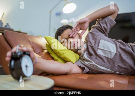 muslim man in the bed turning the alarm off Stock Photo