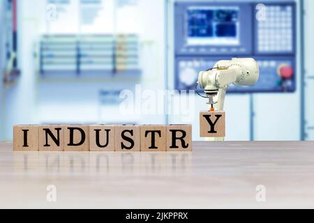 Industrial robot picking wooden letter for build message on wooden desk and machine blue tone color on blurred background Stock Photo