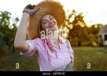 Beautiful young woman gardening outside in summer nature Stock Photo