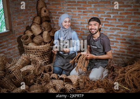 smiling woman in veil using tablet and craftsman Stock Photo
