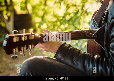 Man playing acoustic guitar in nature on a sunny day Stock Photo