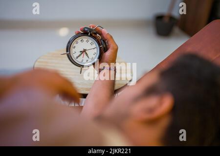 muslim man in the bed turning the alarm off Stock Photo