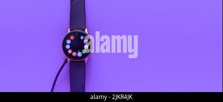 Smartwatch charging.Smart watch on wireless charging with on-screen charging indicator.Blurred image.Place for text.copy space.Banner,Advertisement.Te Stock Photo