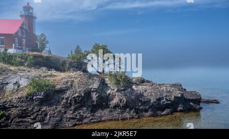Eagle Harbor Lighthouse watches over Eagle Harbor and Lake Superior on a misty day,, near Eagle Harbor, Michigan. Stock Photo