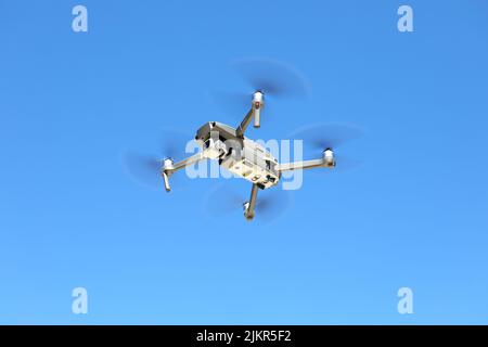 DJI Mavic drone in the air against a blue sky Stock Photo