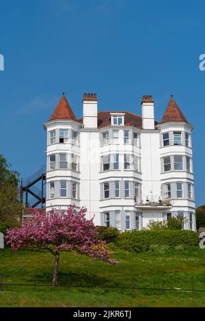 Pink tree blossom, Cliff Gardens below San Remo Mansions, San Remo Parade, Westcliff on Sea, Essex, UK. 1900s Edwardian house property above seafront Stock Photo