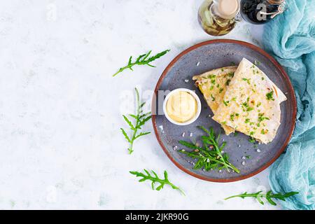 Fried pita bread with scrambled eggs, tomatoes, meat and cheese. Stuffed lavash Stock Photo