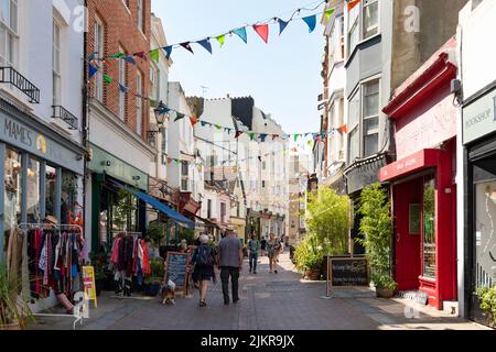 George Street - pedestrianised street with shops and pavement cafes in Hastings Old Town in summer - Hastings, East Sussex, England, UK Stock Photo