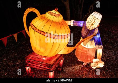 Chinese New Year lantern art. A man pours tea from a giant teapot Stock Photo