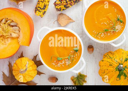 Pumpkin cream soup on white wooden background. Directly above, close up Stock Photo
