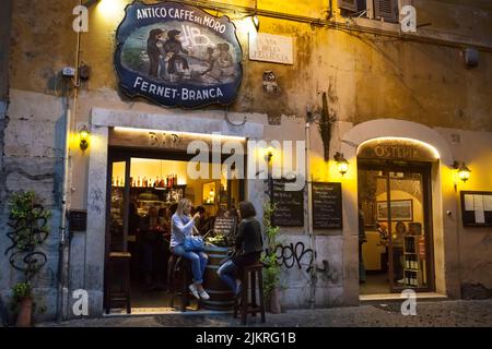 Two girls sitting on the Antico Caffe del Moro terrace in Trastevere, Rome Stock Photo