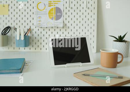 Close-up of digital tablet with notepad and cup of coffee on desk of business person at office Stock Photo