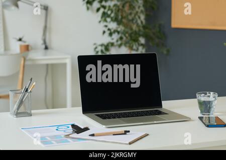 Close-up of laptop and documents on desk at modern office Stock Photo