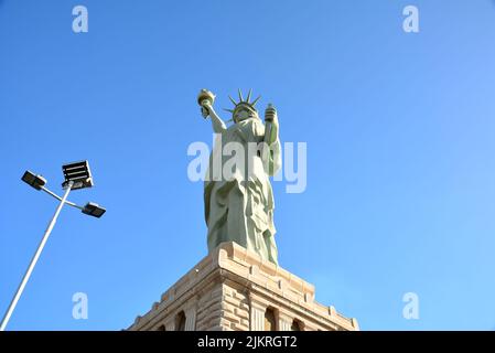 Imitation of the Statue of Liberty, on a concrete pedestal, led lamp post, blue sky in the background, Brazil, South America, bottom-up view Stock Photo