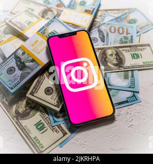 Berlin, Germany - February 02, 2022: Instagram app logo on Apple iPhone screen, background of the money, business concept photo Stock Photo