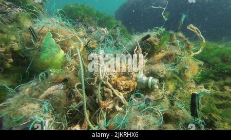 Lost fishing gear lies underwater on the seabed. Problem of ghost gear - any fishing gear that has been abandoned, lost or otherwise discarded. It is Stock Photo