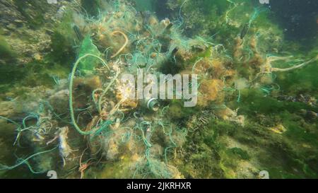 Lost fishing gear lies underwater on the seabed. Problem of ghost gear - any fishing gear that has been abandoned, lost or otherwise discarded. It is Stock Photo