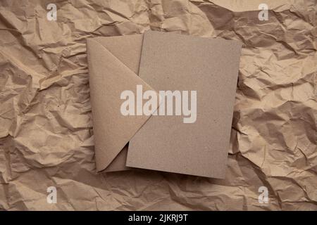 Blank card with kraft brown paper envelope template mock up on crumpled brown paper Stock Photo