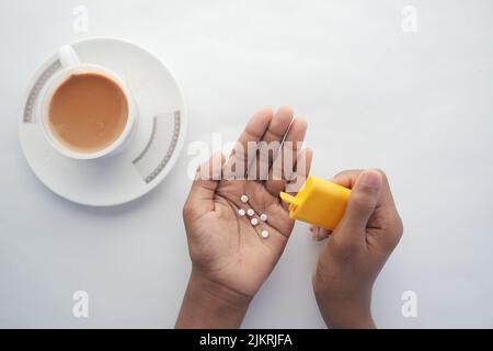 young man putting artificial sweetener in tea, Stock Photo