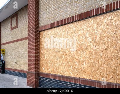 Boarded up windows of a supermarket that has recently closed down. Stock Photo