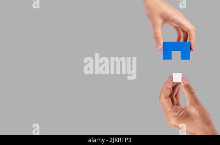 Banner with man and woman hands holding two matching puzzle pieces. Partnership, connection concept. Mutual understanding, support in relations. Copy space. High quality photo Stock Photo