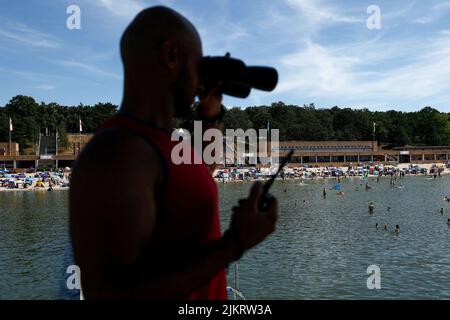 Berlin, Germany. 03rd Aug, 2022. A swimming supervisor observes the bathing activities at the Wannsee lido. 33 degrees Celsius attracts many visitors to the open-air pool. Credit: Carsten Koall/dpa/Alamy Live News Stock Photo