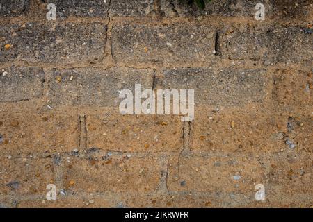Clay wall background. Detail of old wall with roughly built bricks pattern and mixed pebbles. Texture of rough rustic wall with copy space Stock Photo