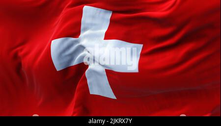 Close-up view of the swiss national flag waving in the wind. Switzerland is a landlocked country located in Europe. Fabric textured background. Select Stock Photo