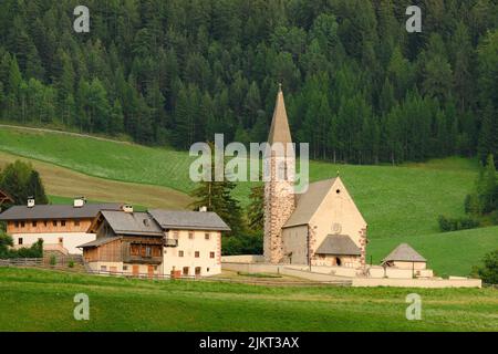 Stunning view of the Funes Valley (Val di Funes) with the Santa Maddalena Church during a beautiful sunset. Santa Magdalena, Dolomites, Italy. Stock Photo
