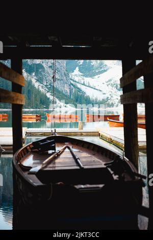 (Selective focus) Stunning view of some wooden boats floating on the Lake Braies (Lago di Braies) with defocused mountains in the distance. Stock Photo