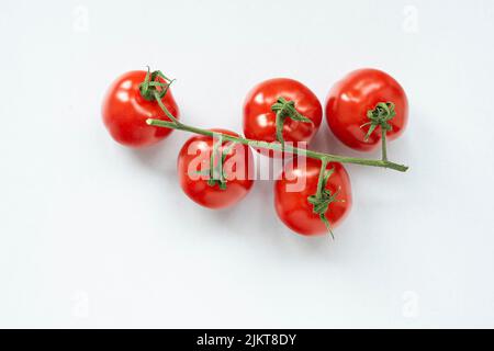 A closeup of a bunch of cherry tomatoes isolated on white background Stock Photo