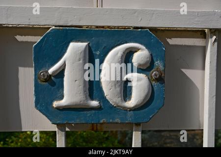 A closeup shot of the number sixteen sign on a blue background Stock Photo
