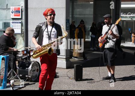 A young man playing saxophone in downtown Vancouver, British Columbia, Canada Stock Photo