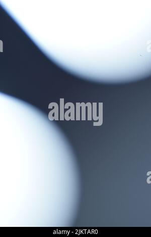 A vertical shot of light blue bokeh lights on blue background Stock Photo