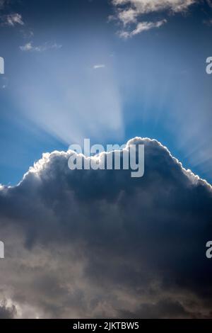 Sun beams behind clouds. Stock Photo